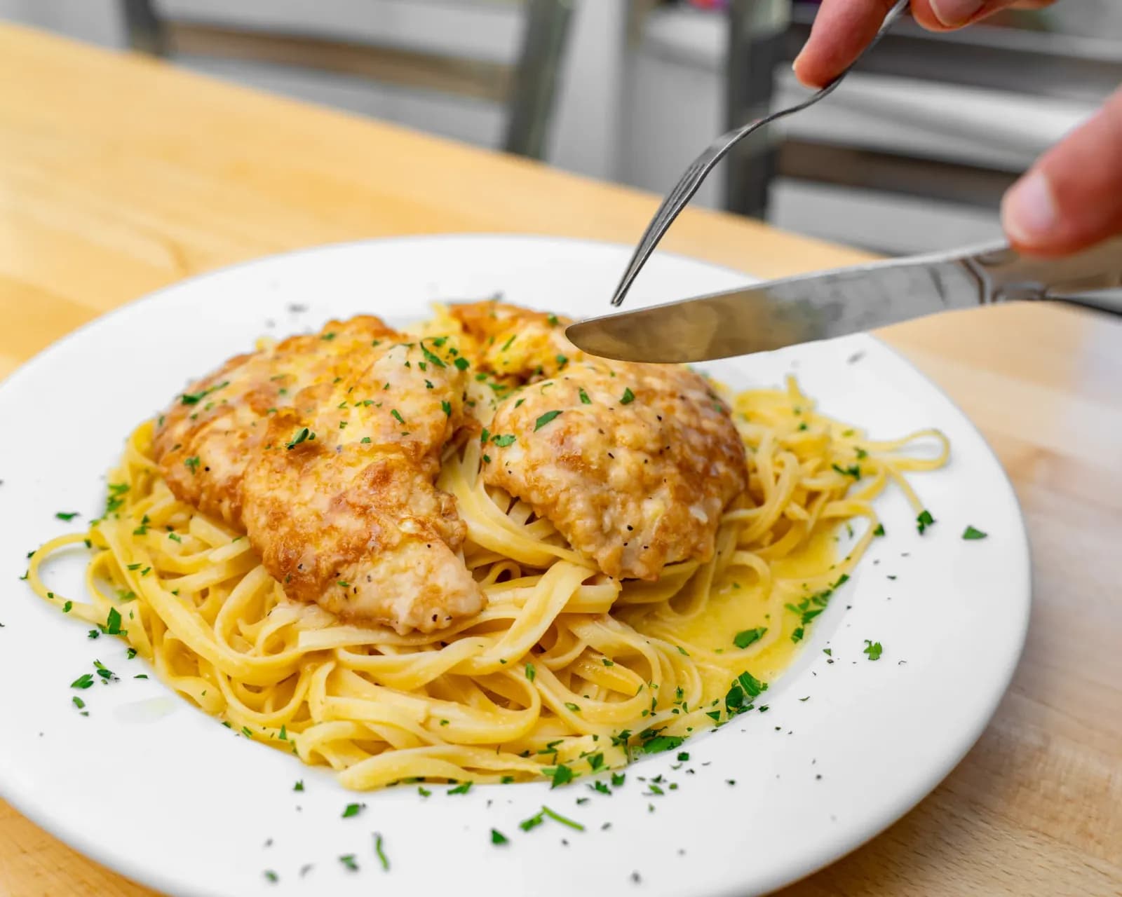 Chicken francese in butter and lemon sauce over pasta